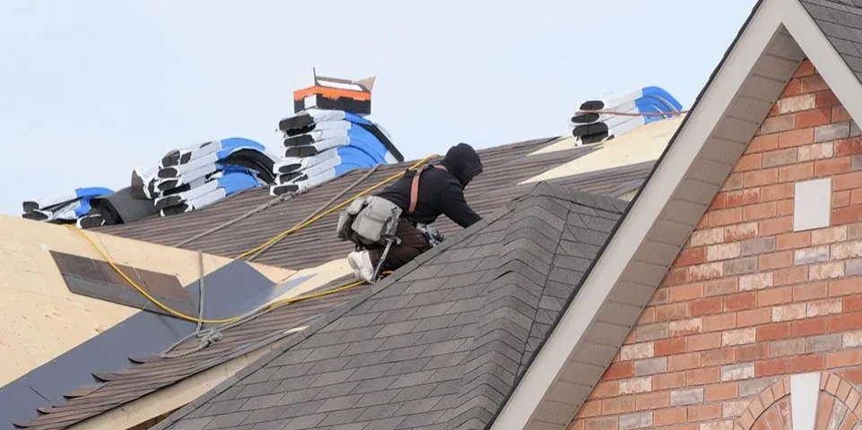 Roofer installing asphalt shingles